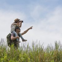 Father and daughter looking through binoculars