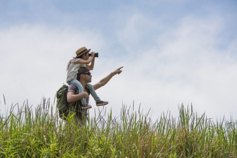 Father and daughter looking through binoculars