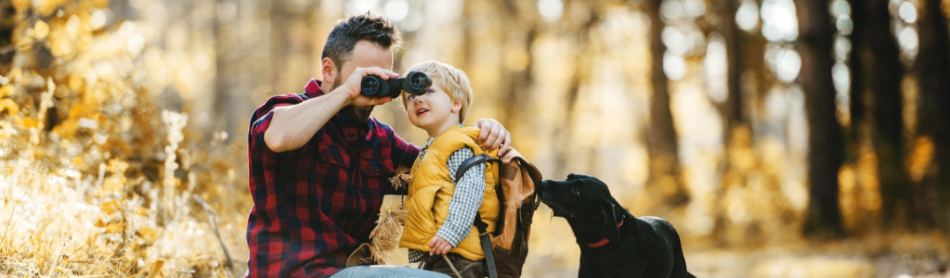 Father holding binoculars up for son Father holding binoculars up for son